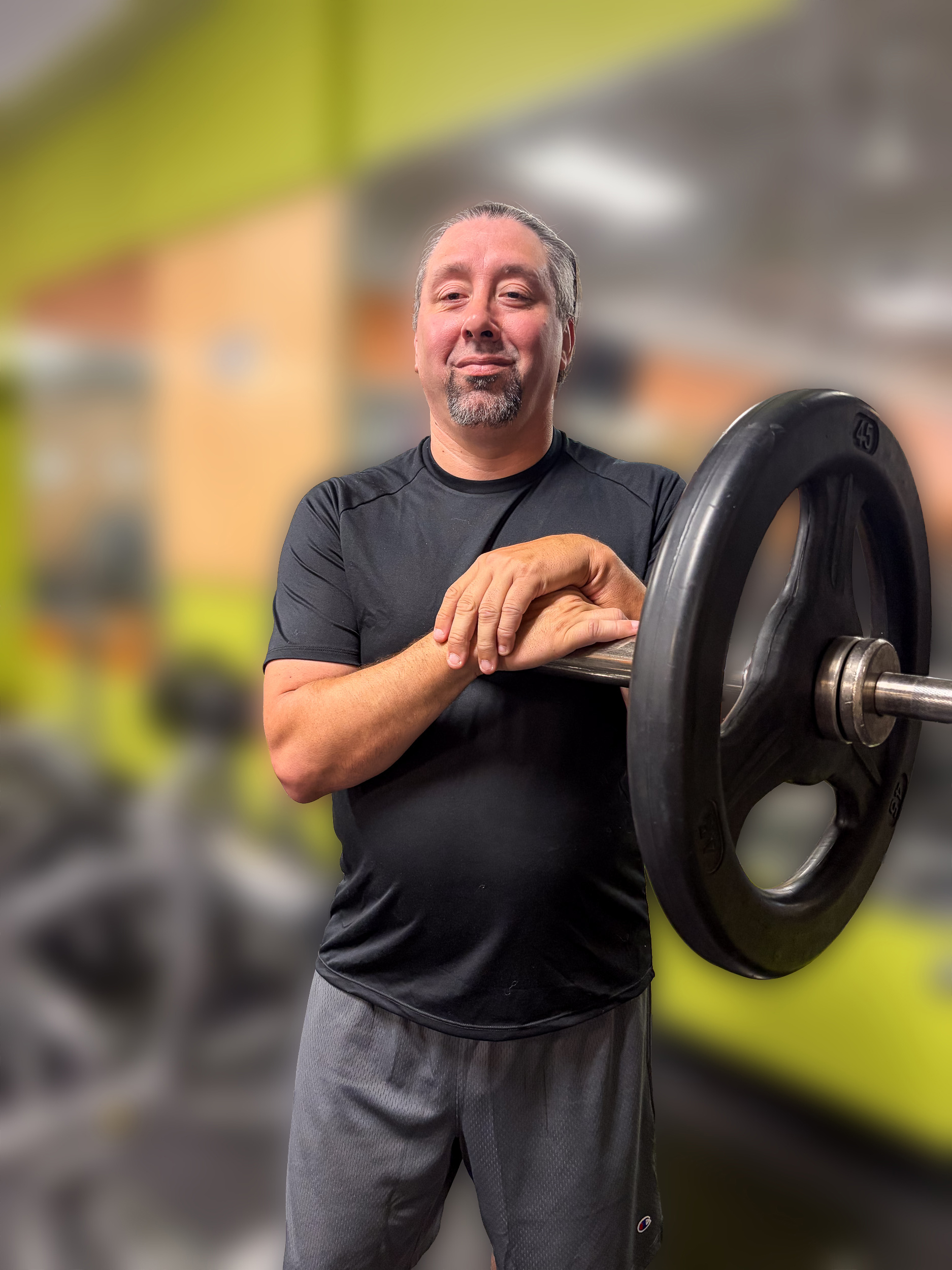 Lewis Mendez standing beside a loaded barbell plate
