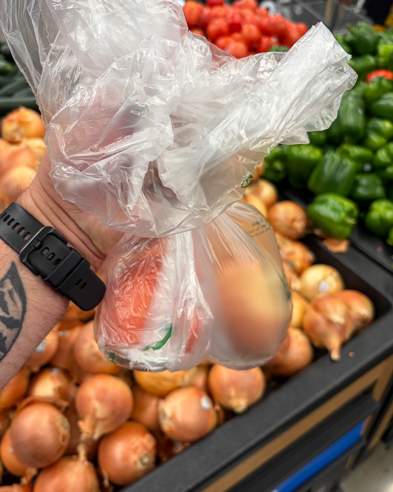 Fresh vegetables being selected in the produce section of a grocery store